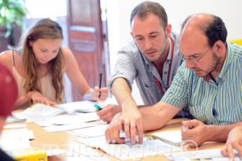 مدرس لغة إنجليزية يشرح شيئًا لطالب في الفصل